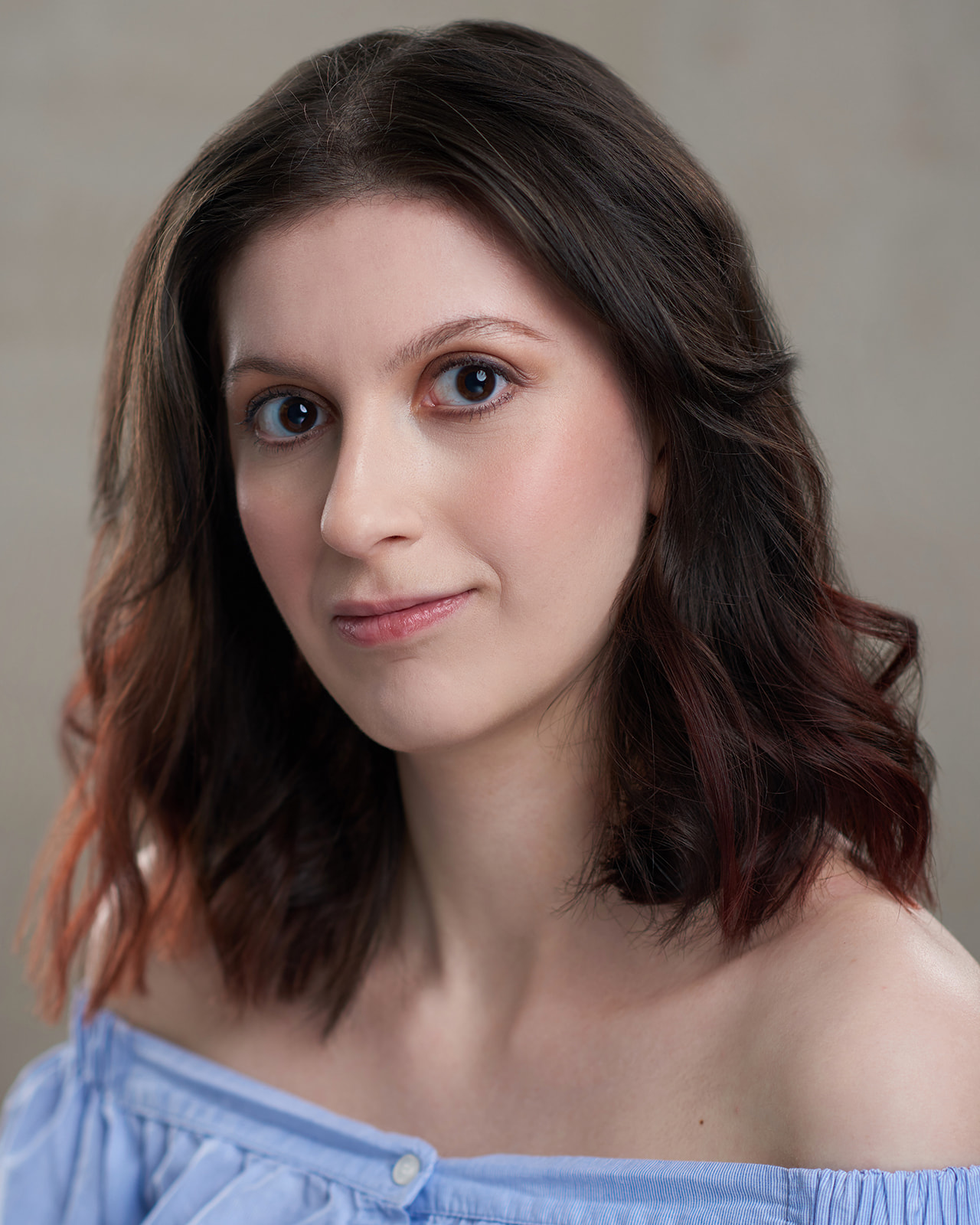 Actress headshot light blue shirt and brown hair